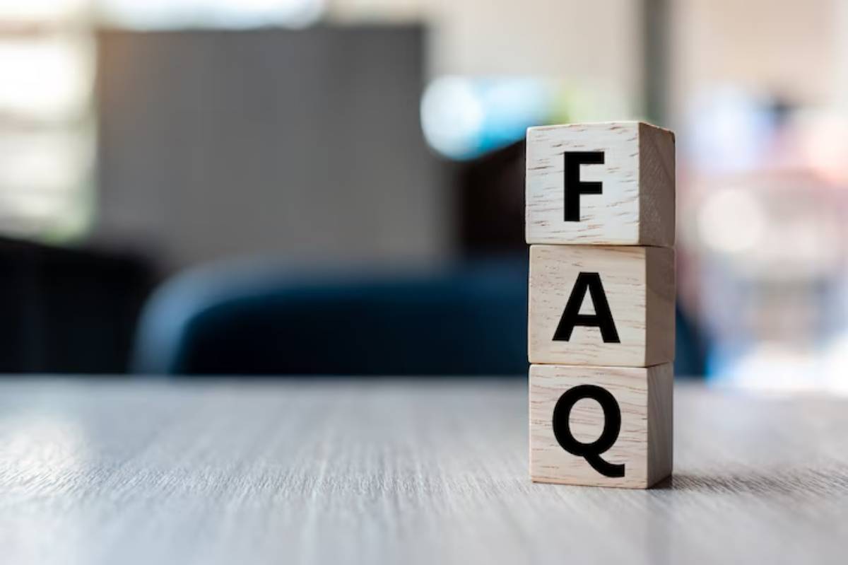 Three wooden blocks stacked vertically, displaying the letters F, A, and Q, on a blurred background.