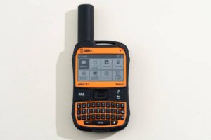 A rugged handheld satellite communicator with an orange and black design, featuring a screen and QWERTY keyboard for messaging.